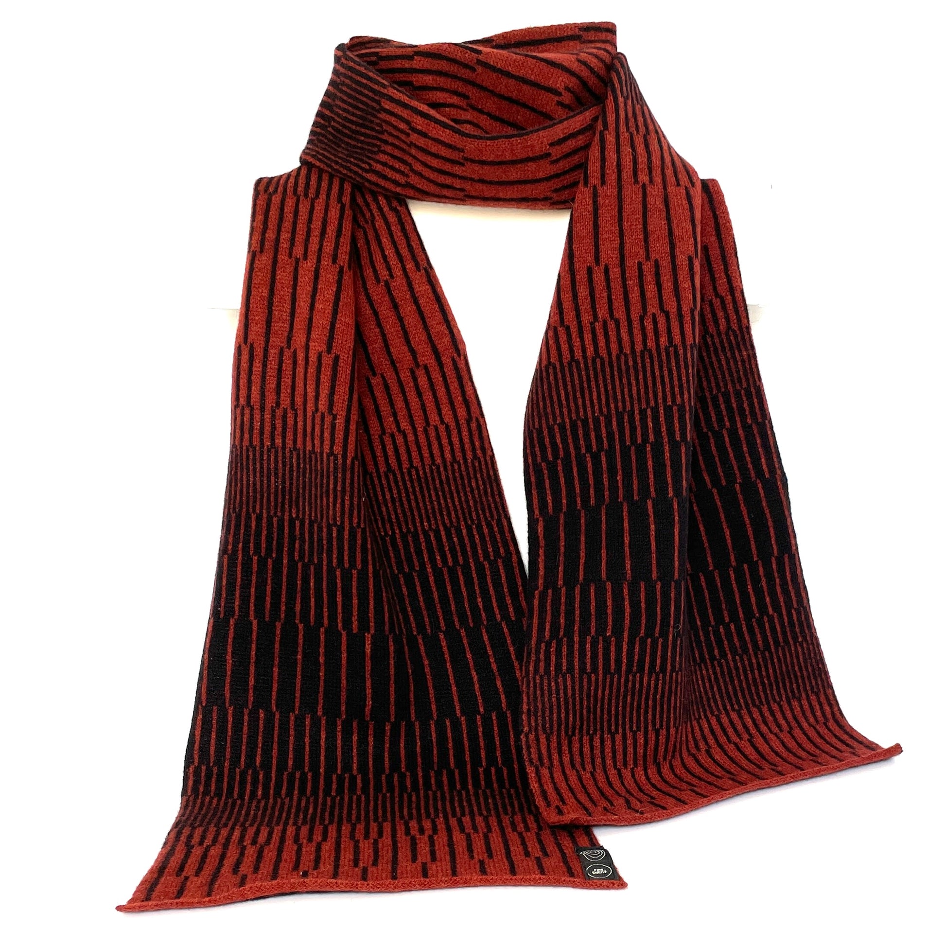 Sienna Brown and Navy Blue handcrafted merino Lambswool striped Reverb Scarf hanging on a white display stand  against a bright and neutral background. Pom Shanty Knitwear.