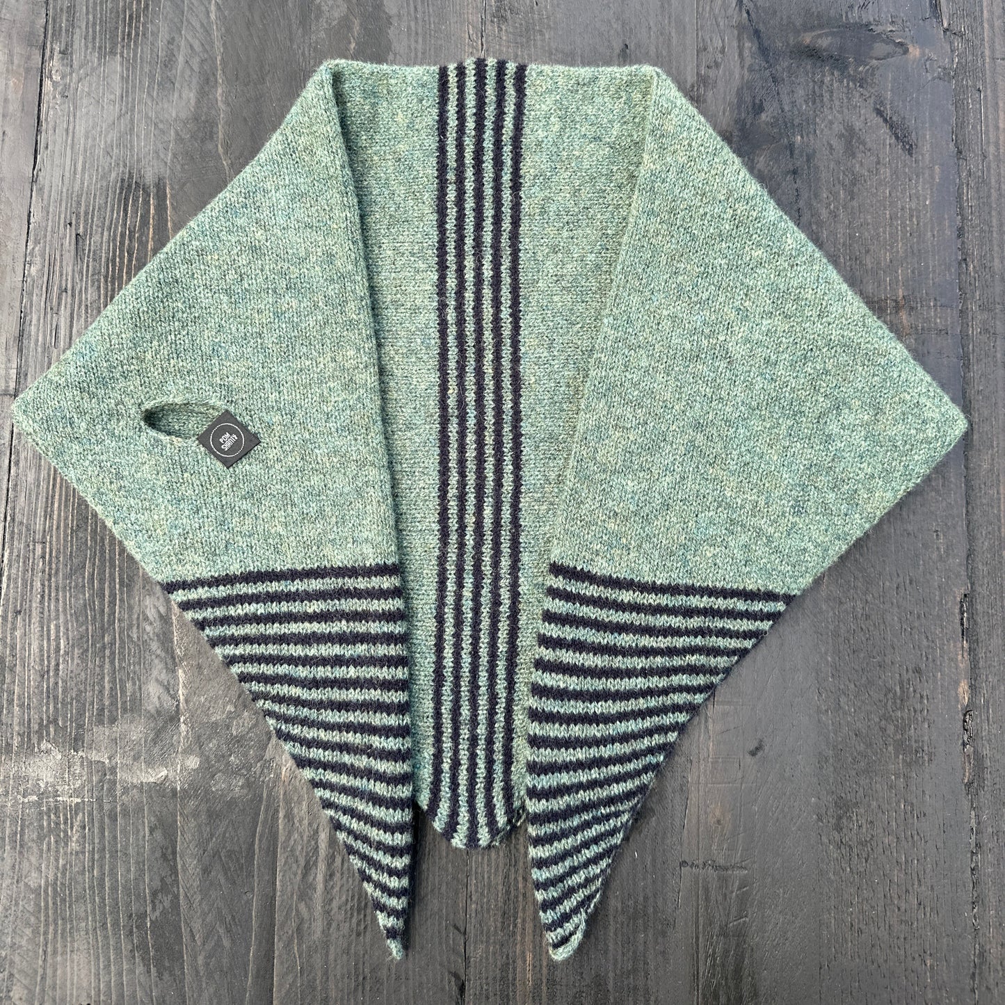 Merino lambswool double layer striped, multicoloured, peacock green and navy blue pull through triangle scarf / kerchief / neckerchief for women, men, unisex on a dark wooden table.