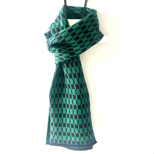 Navy blue and cossack green handcrafted Merino Lambswool geometric patterned Morse scarf on a white hanger against a white background.  Pom Shanty Knitwear.
