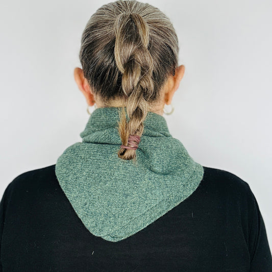back view of Woman in a black top wearing merino lambswool double layer solid colour, peacock green pull through triangle scarf / kerchief / neckerchief for women, men, unisex on a neutral background