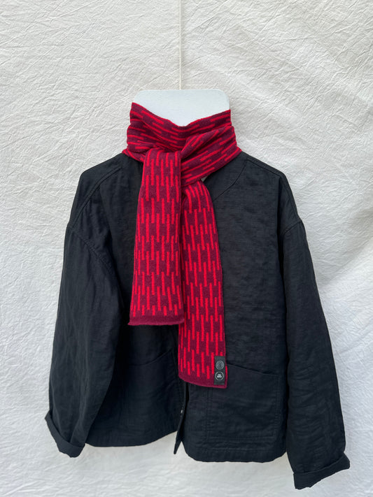 Burgundy and Red Rain Skinny Scarf, lambswool, draped over a black jacket