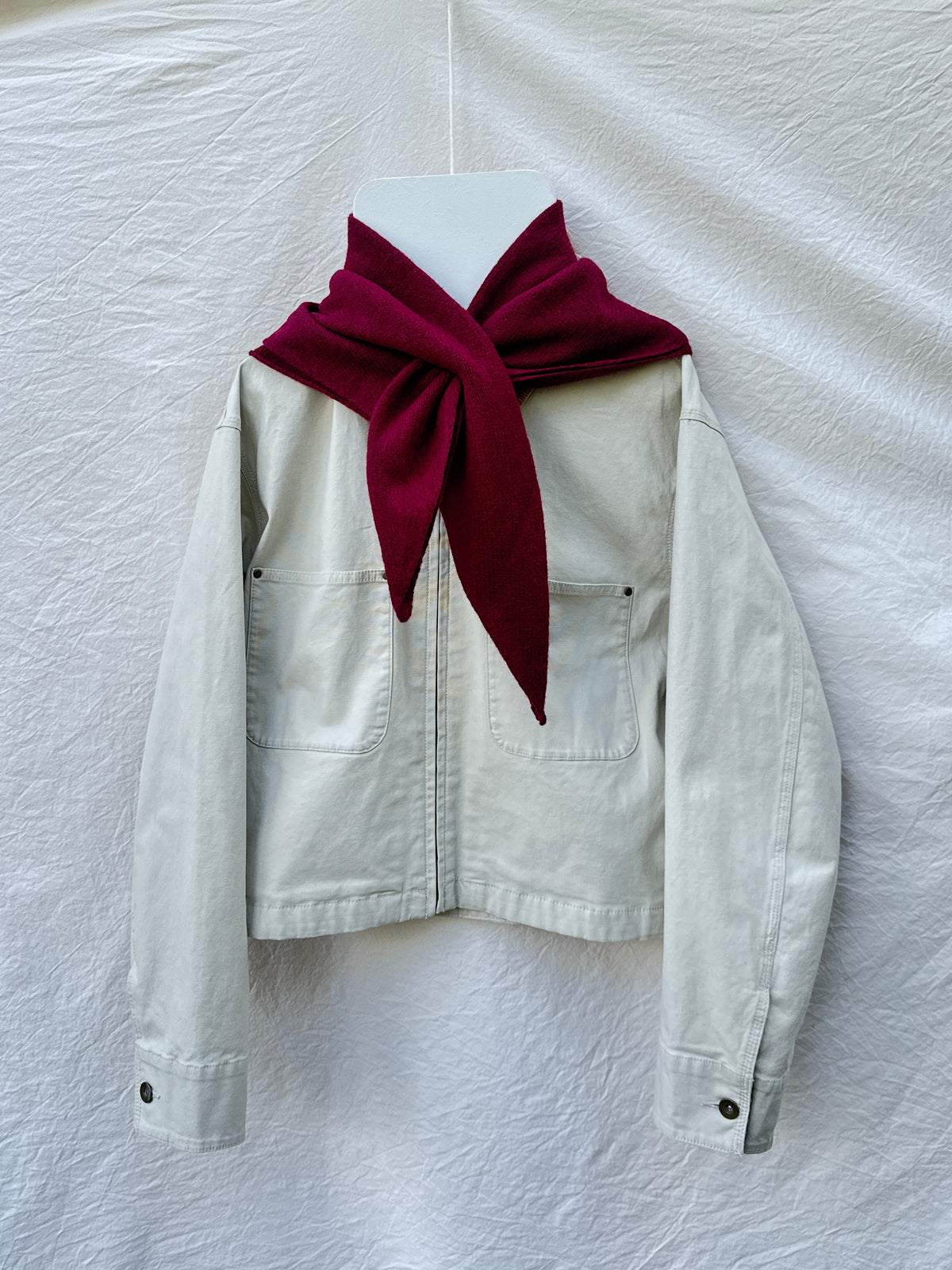 Burgundy Triangle Scarf, merino wool, draped over a cream jacket
