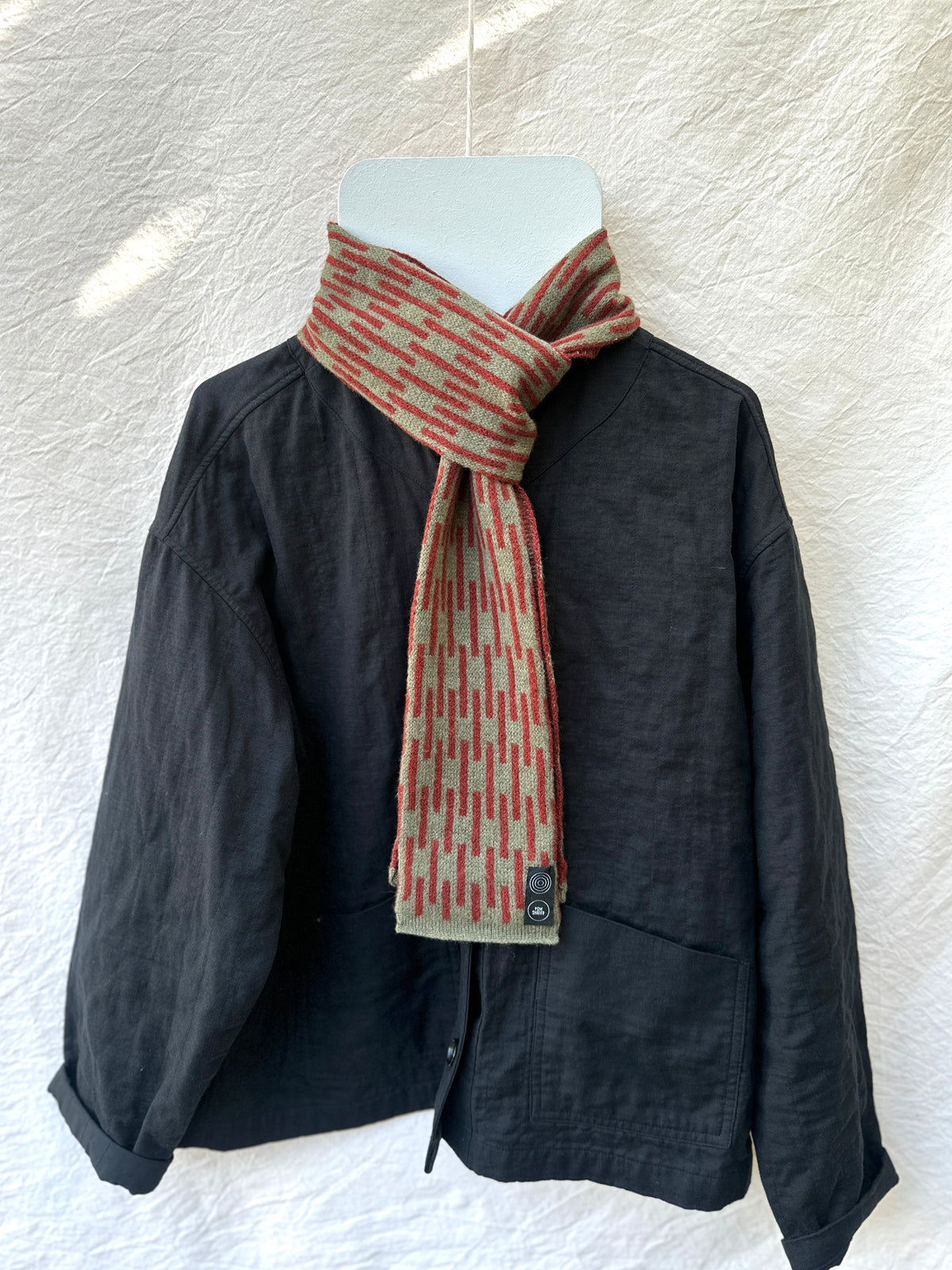 Olive and Sienna Brown Rain Skinny Scarf, lambswool, draped over a black jacket
