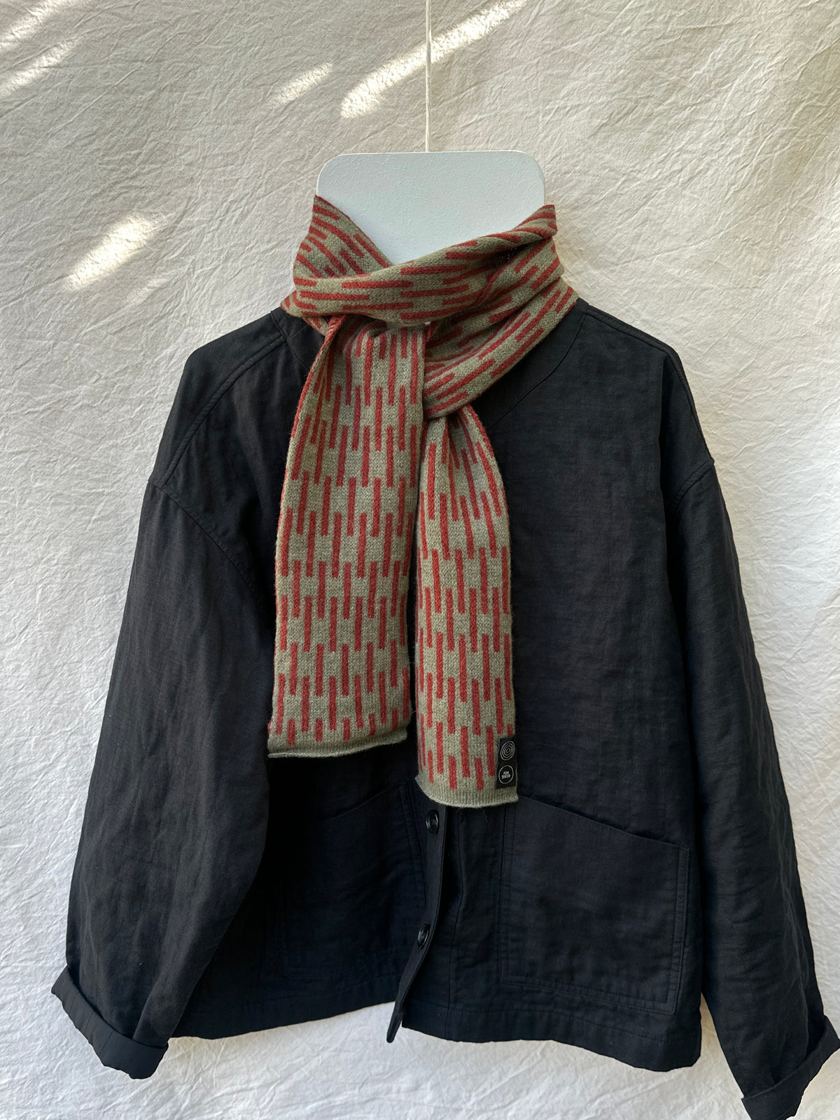 Olive and Sienna Brown Rain Skinny Scarf, lambswool, draped over a black jacket