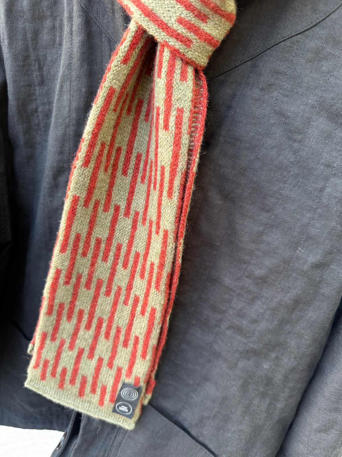 Olive and Sienna Brown Rain Skinny Scarf, lambswool, draped over a black jacket