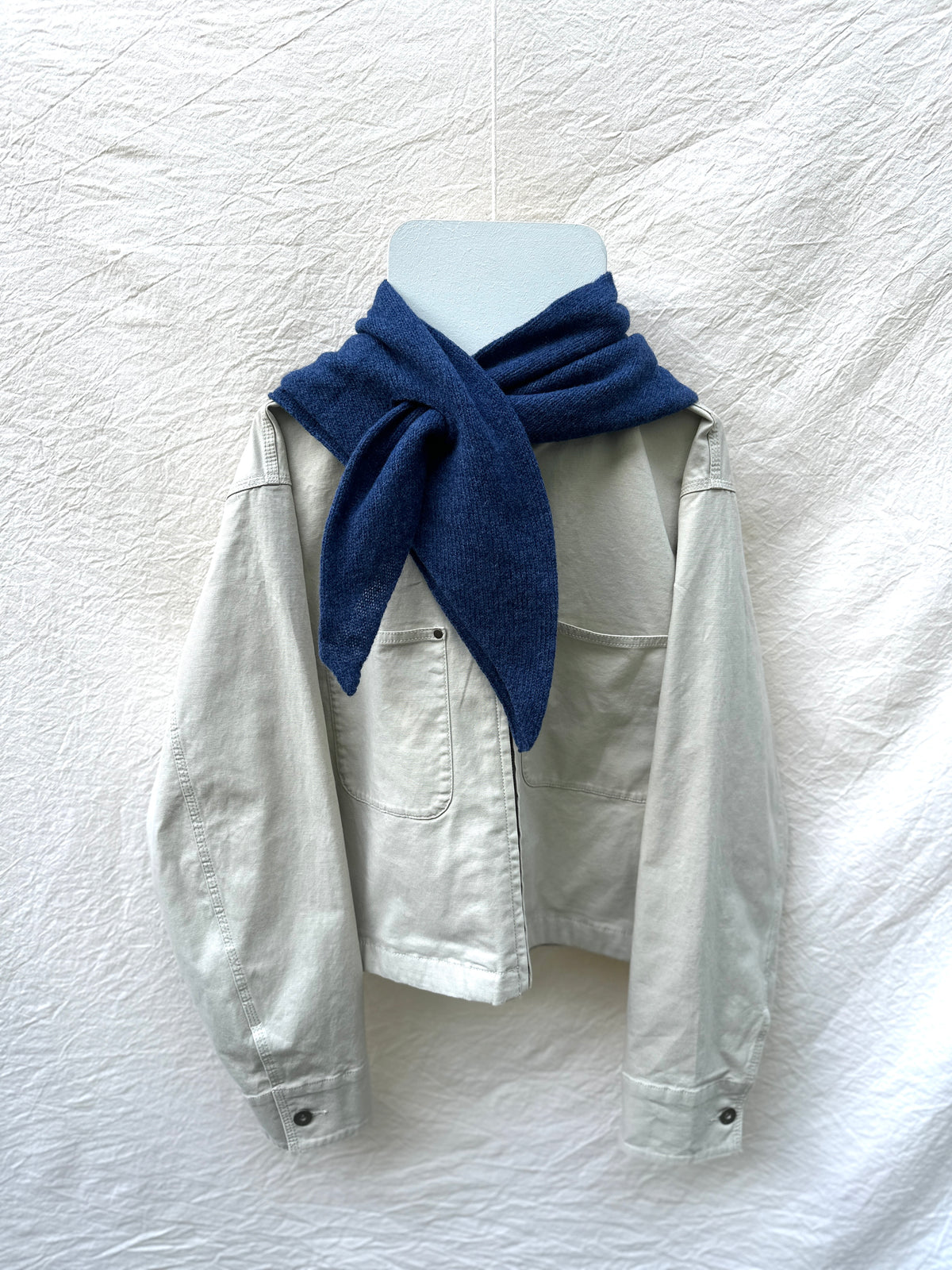 Rhapsody Blue Triangle Scarf, merino wool, draped over a cream jacket